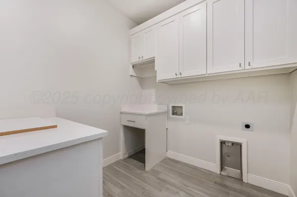 a kitchen with white cabinets and a wooden floor