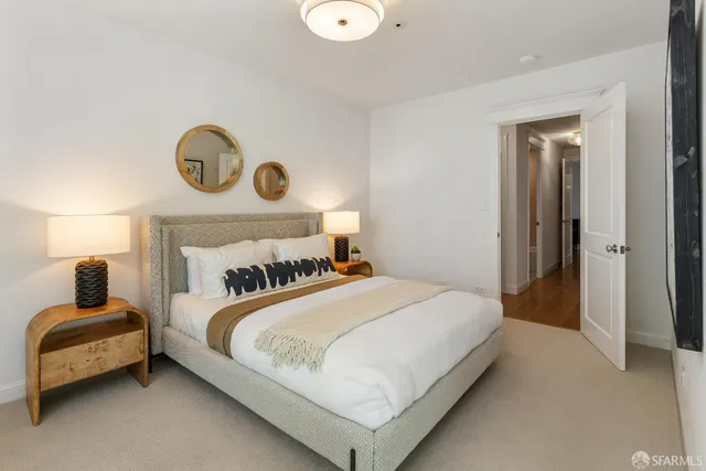 a bedroom with a bed and painting on the wall