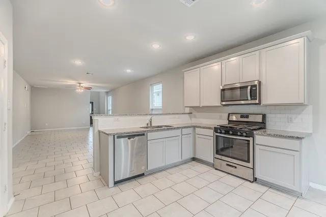 a kitchen with appliances cabinets and furniture