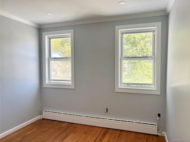 a view of a room with wooden floor and a window