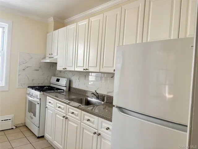 a kitchen with stainless steel appliances white cabinets and a refrigerator