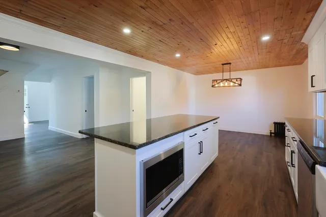 a kitchen with a stove and wooden floor