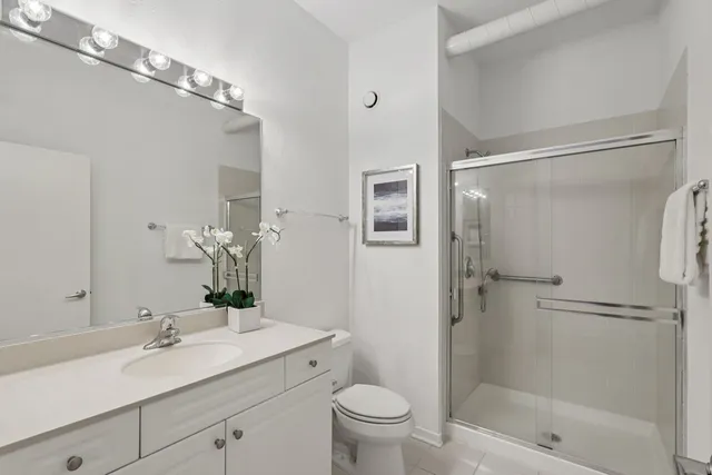 a bathroom with a granite countertop sink toilet and shower