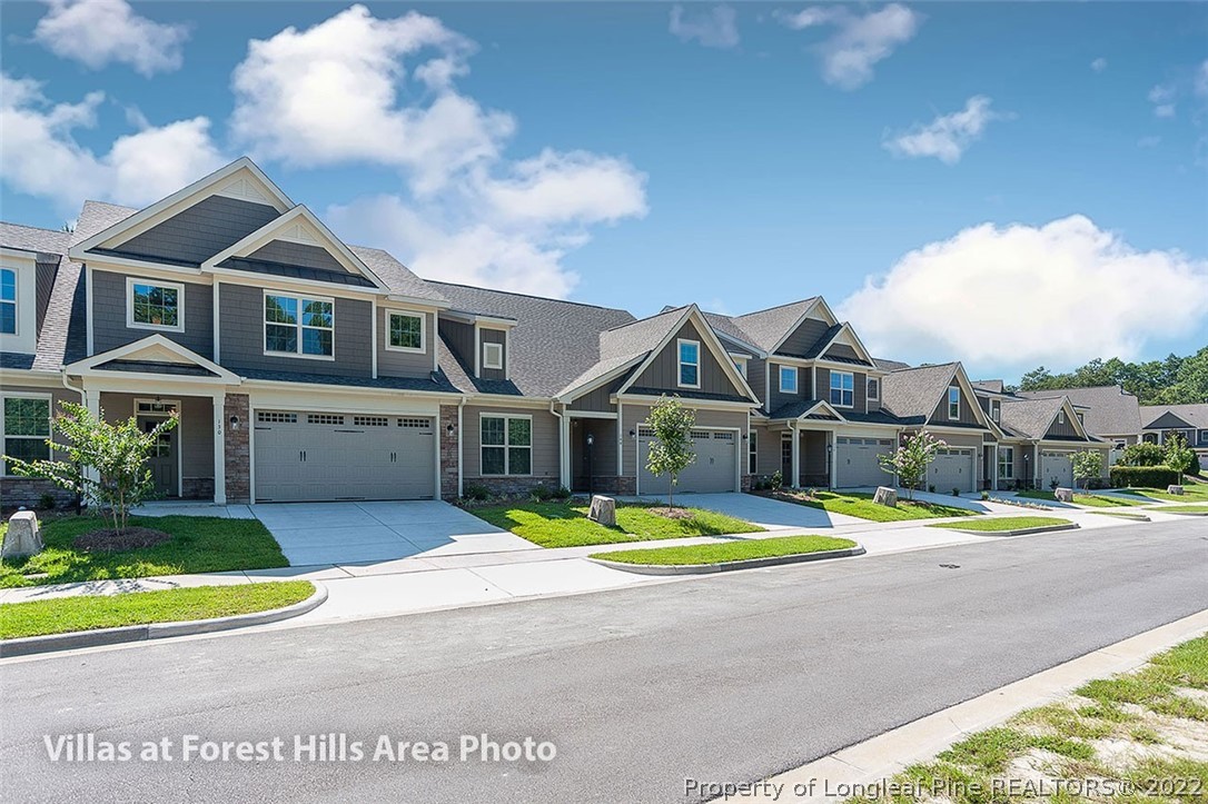 45 Winged Foot Road, Unit 8 Pinehurst, NC 28374 - Photo 6 of 13 a front view of a house with a yard and potted plants