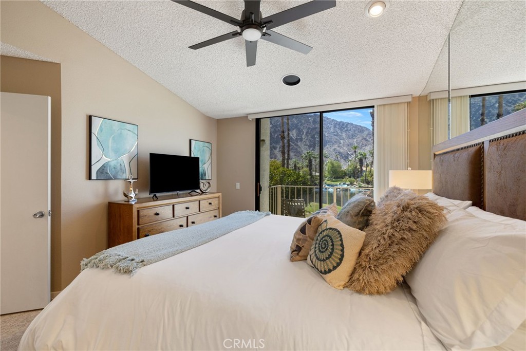 79822 Olympia Fields La Quinta, CA 92253 - Photo 20 of 48 a bedroom with a bed and a flat tv screen on dresser