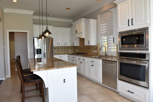 a kitchen with stainless steel appliances granite countertop a stove a sink and a refrigerator
