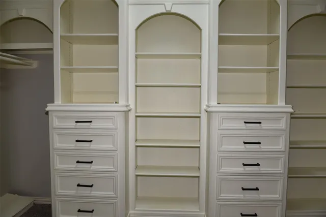 a view of walk in closet with empty racks