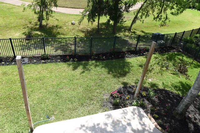 a view of backyard with potted plants and large trees