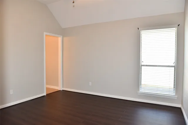 an empty room with wooden floor and a window