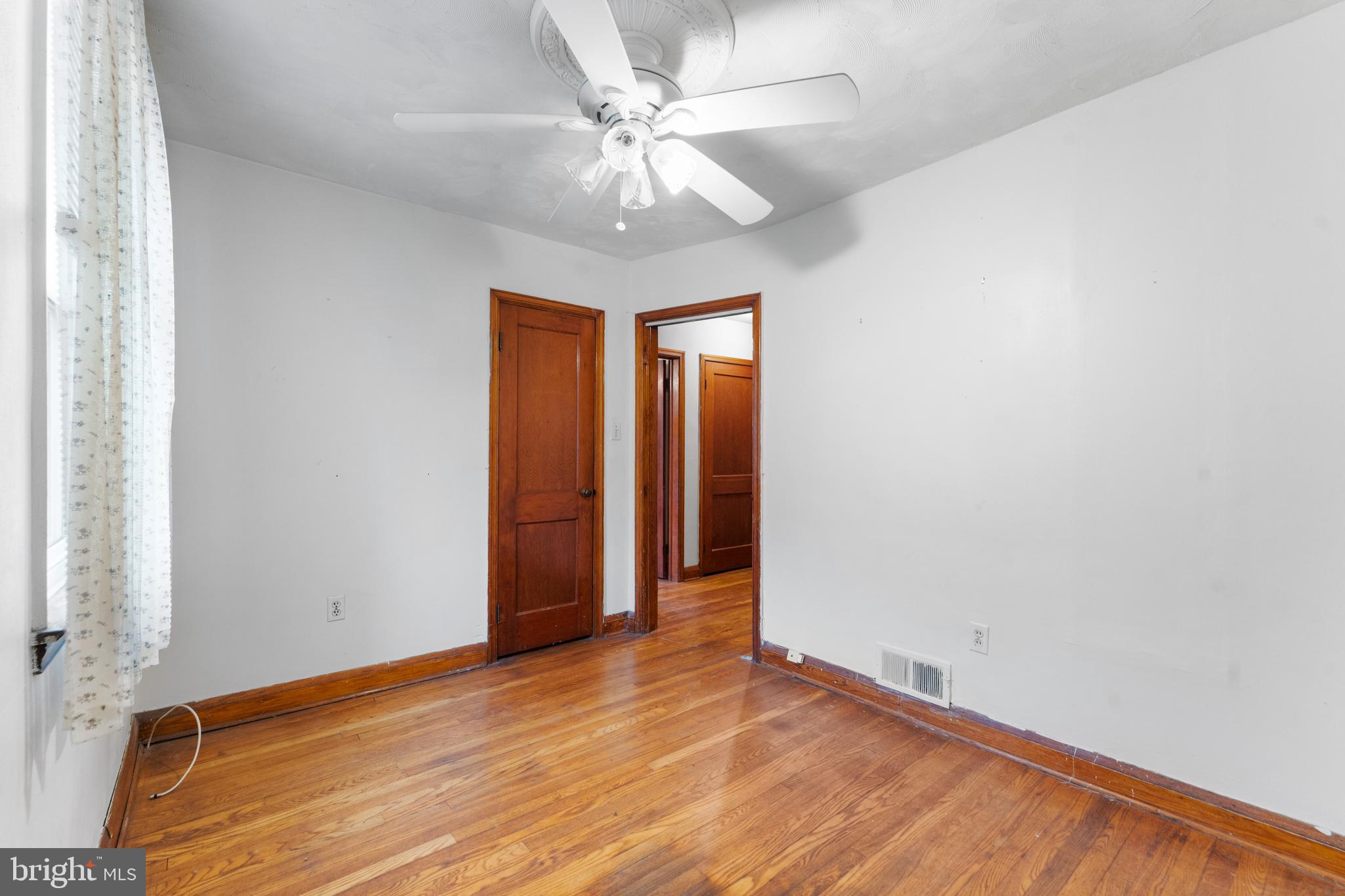 24 Mansion Road Linthicum Heights, MD 21090 - Photo 16 of 35 an empty room with wooden floor fan and windows