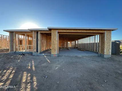 a view of an empty room with wooden floor and fan