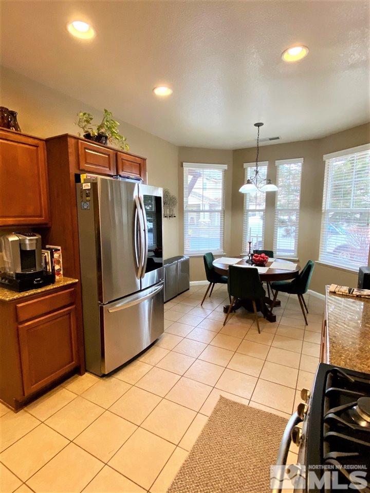 590 Needles Court Reno, NV 89521 - Photo 3 of 15 a kitchen with refrigerator and chairs