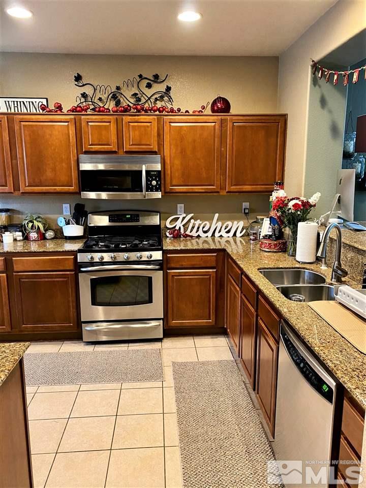 590 Needles Court Reno, NV 89521 - Photo 4 of 15 a kitchen with stainless steel appliances a stove a sink and a microwave