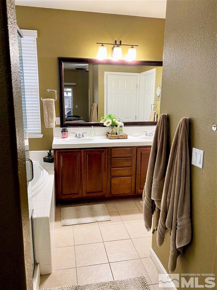590 Needles Court Reno, NV 89521 - Photo 10 of 15 a bathroom with a sink a mirror and a bathtub