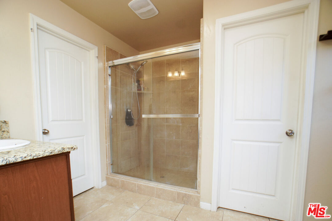 6014 Samuelson Street Bakersfield, CA 93313 - Photo 12 of 25 a bathroom with a granite countertop shower and a sink