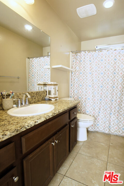 6014 Samuelson Street Bakersfield, CA 93313 - Photo 18 of 25 a bathroom with a granite countertop sink and a mirror