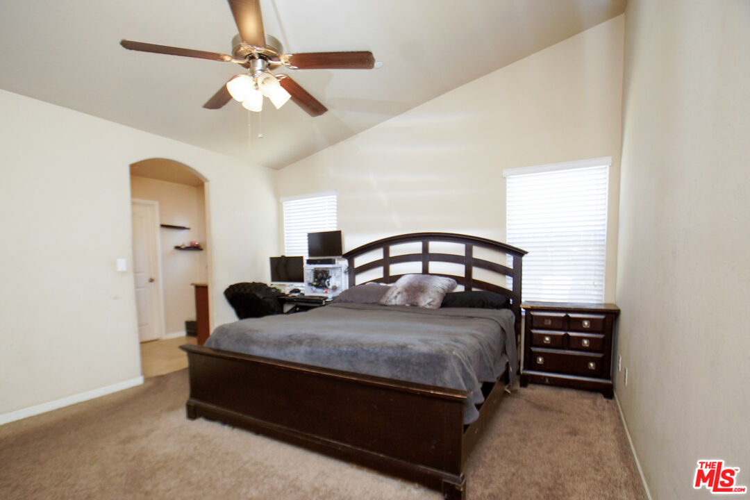 6014 Samuelson Street Bakersfield, CA 93313 - Photo 7 of 25 a bedroom with a bed a chandelier and a dresser