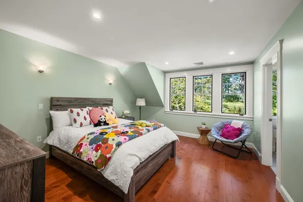 a bedroom with a bed and wooden floor