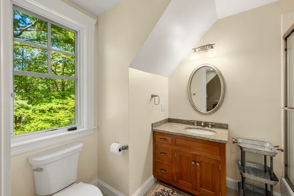 a bathroom with a toilet a sink and a mirror