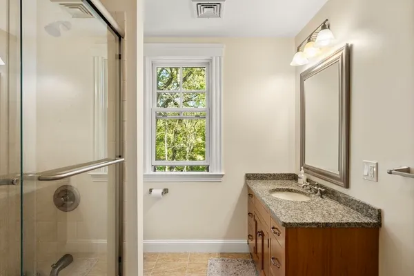 a bathroom with a granite countertop sink and a mirror