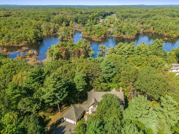 an aerial view of residential houses with outdoor space and trees