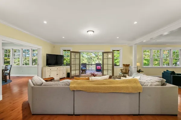 a living room with furniture flat screen tv and a large window