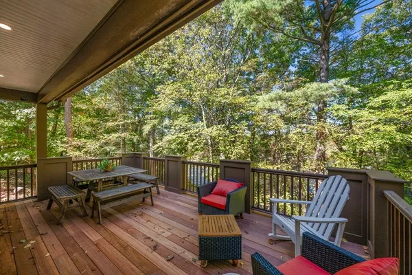 a balcony with wooden floor and outdoor seating