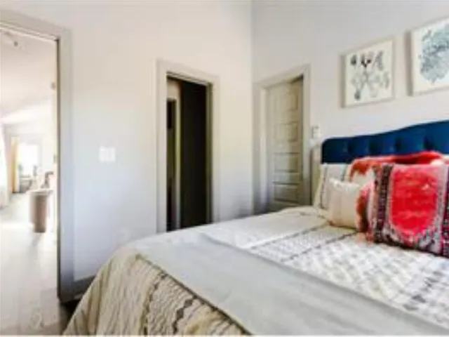 a bedroom with a bed and painting on the wall