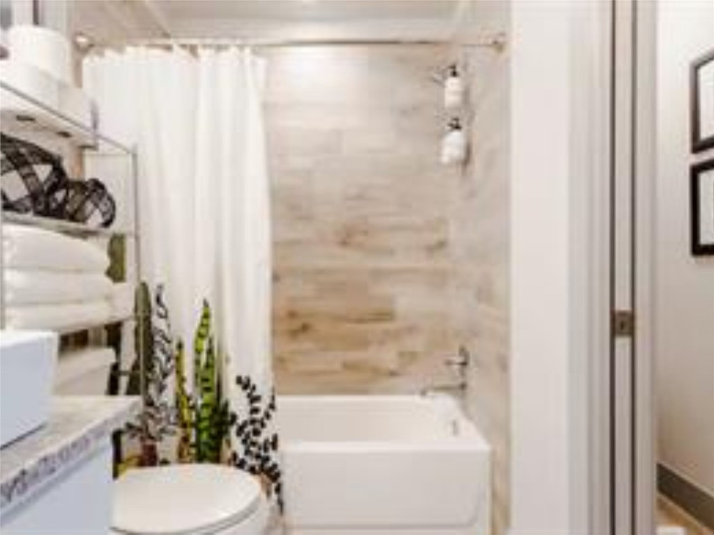 1139 1/2 Poquito Street, Unit 3 Austin, TX 78702 - Photo 14 of 23 a bathroom with a shower curtain and a sink