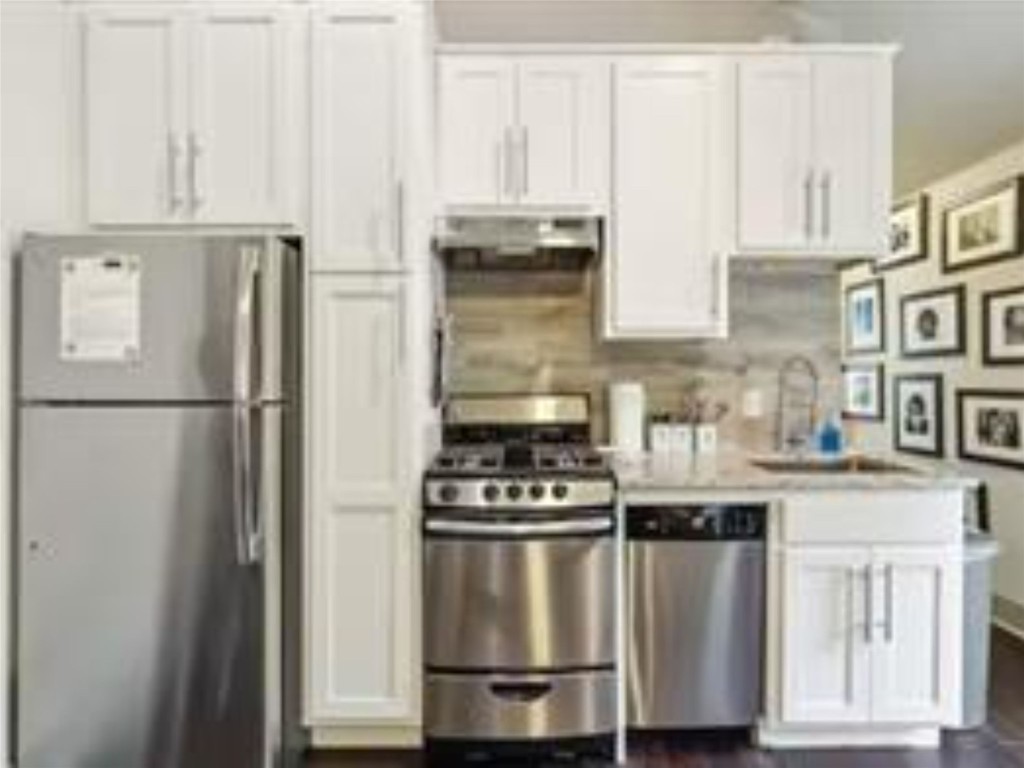 1139 1/2 Poquito Street, Unit 3 Austin, TX 78702 - Photo 7 of 23 a kitchen with cabinets and a stainless steel refrigerator