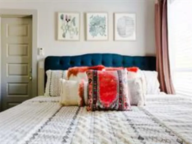 a bedroom with a bed and a painting on the wall