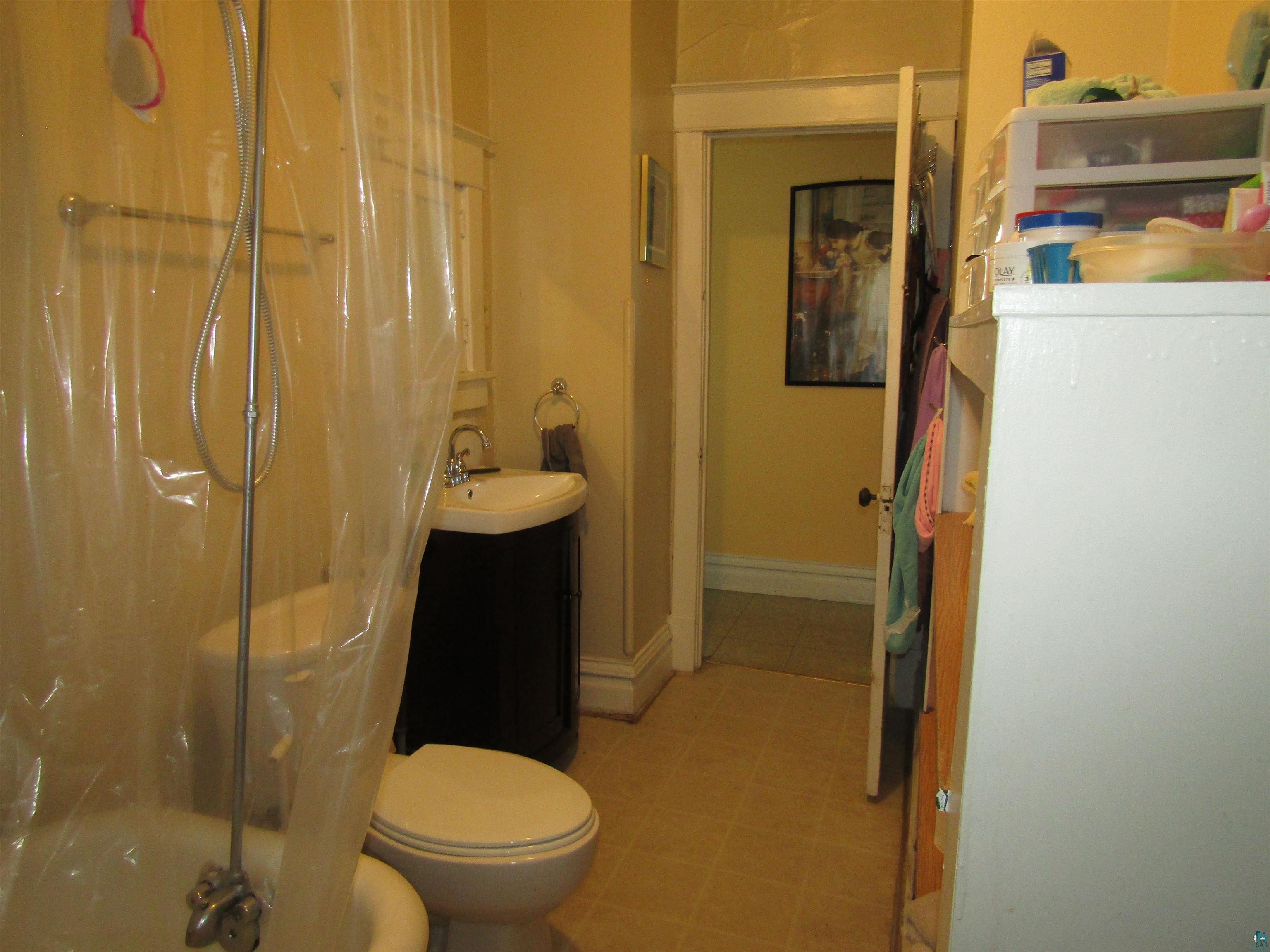 1115 Harrison Street Superior, WI 54880 - Photo 39 of 49 Bathroom featuring a pedestal sink, toilet, and bathtub with a shower fixture