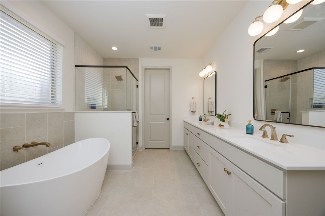 4007 Pacific Crest Way Bryan, TX 77802 - Photo 19 of 28 a bathroom with a double vanity sink mirror and bathtub