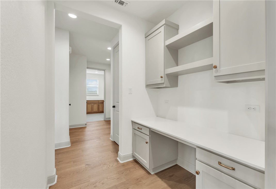 4007 Pacific Crest Way Bryan, TX 77802 - Photo 30 of 43 a hallway with white cabinets and wooden floor
