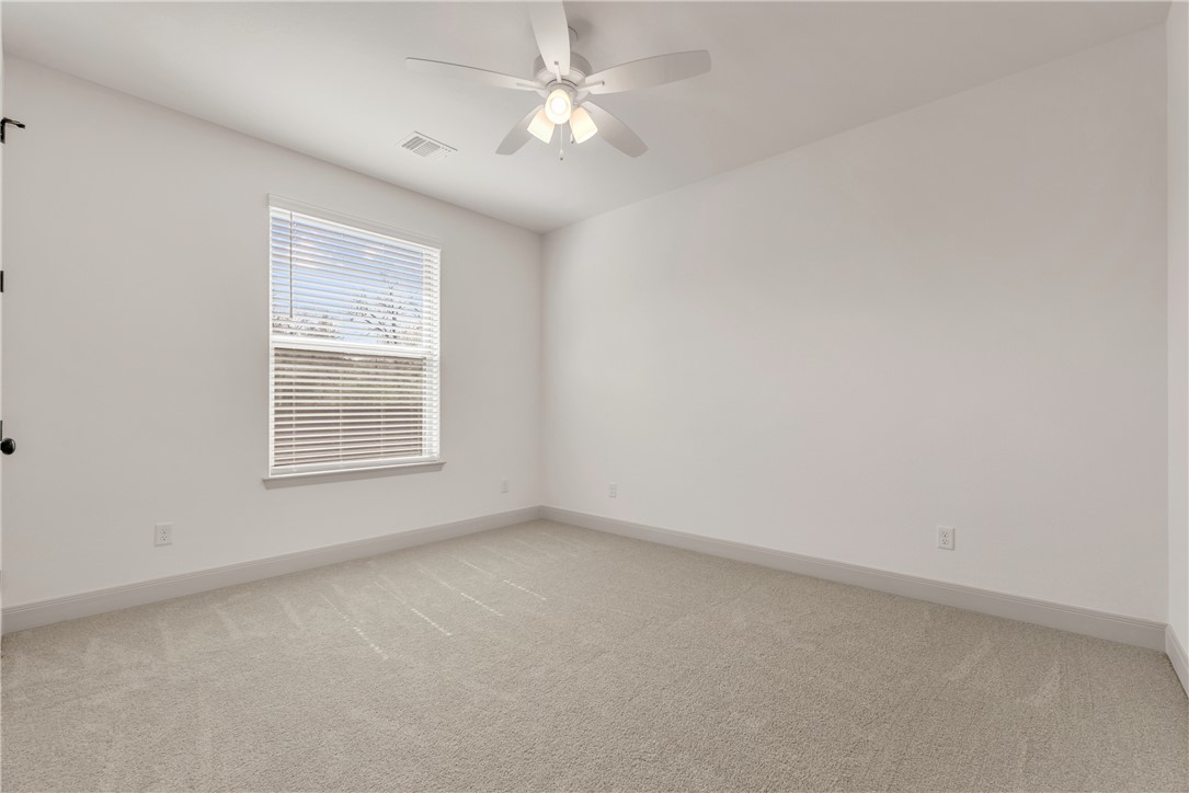 4007 Pacific Crest Way Bryan, TX 77802 - Photo 38 of 43 an empty room with a window and a ceiling fan