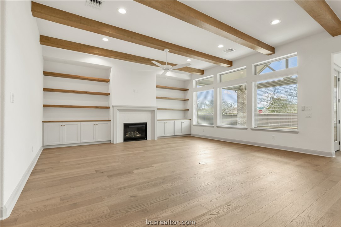 4007 Pacific Crest Way Bryan, TX 77802 - Photo 5 of 43 an empty room with wooden floor fireplace and windows