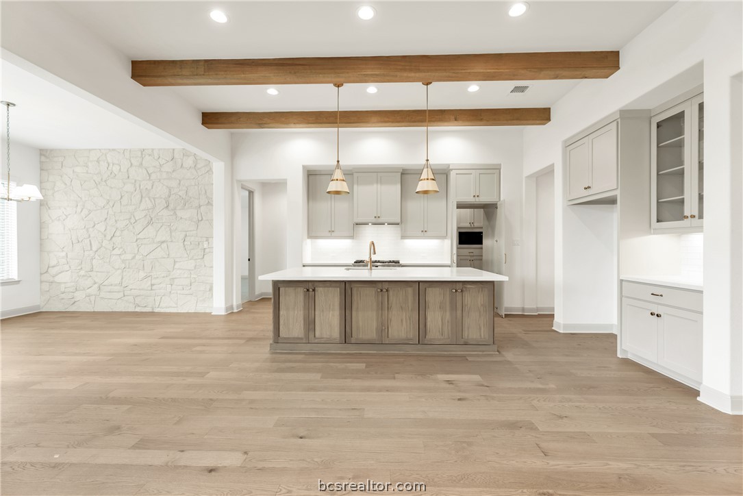 4007 Pacific Crest Way Bryan, TX 77802 - Photo 8 of 43 a large white kitchen with kitchen island a sink stainless steel appliances and cabinets