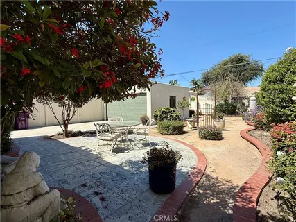 a view of a backyard with table and chairs with wooden fence and plants