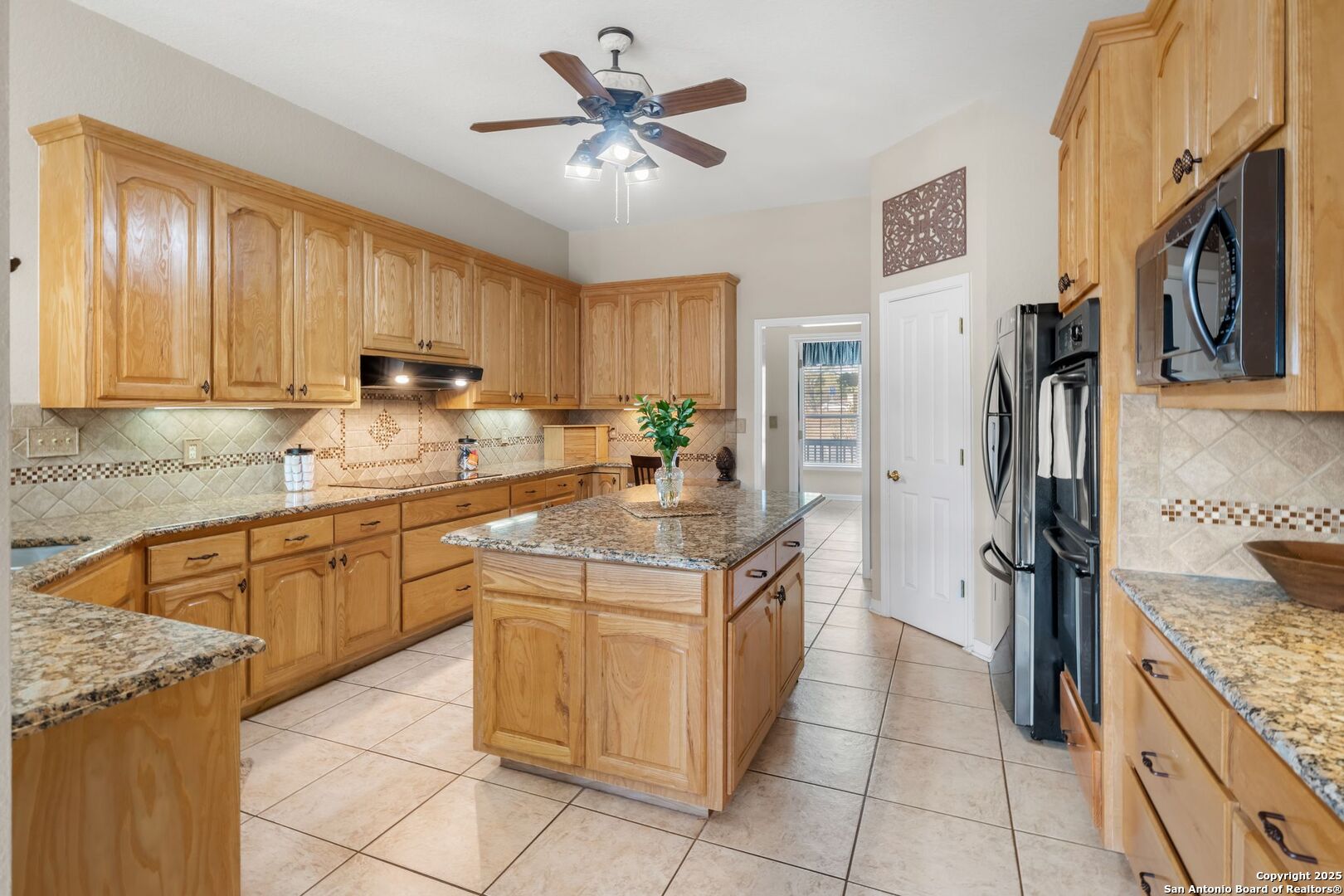 765 Highway 1604 Loop St. Hedwig, TX 78101 - Photo 12 of 50 a kitchen with stainless steel appliances granite countertop a stove refrigerator and cabinets