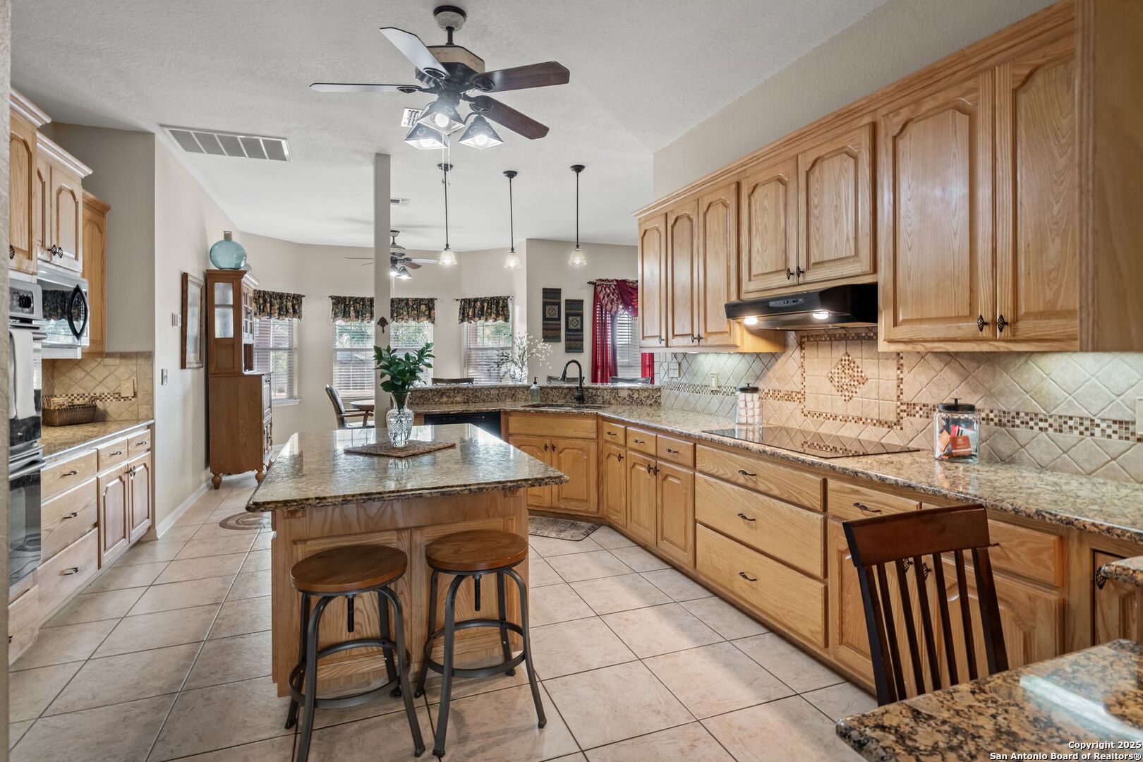 765 Highway 1604 Loop St. Hedwig, TX 78101 - Photo 14 of 50 a kitchen with stainless steel appliances kitchen island granite countertop a sink and cabinets