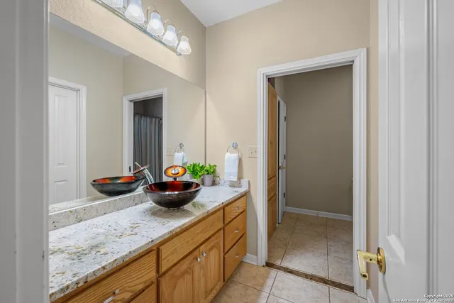 a spacious bathroom with a granite countertop sink a toilet and a mirror