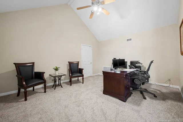 a view of a workspace with furniture and a window