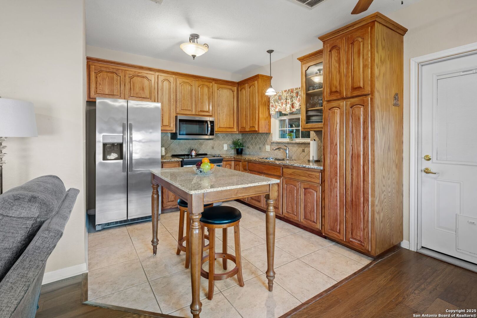 765 Highway 1604 Loop St. Hedwig, TX 78101 - Photo 42 of 50 a kitchen with stainless steel appliances granite countertop a refrigerator a sink a stove and island