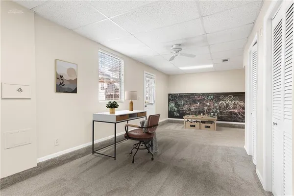 an empty room with a window and a fan