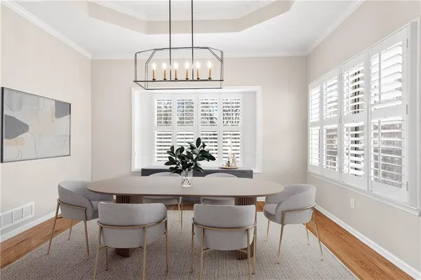 a dining room with furniture a chandelier and wooden floor