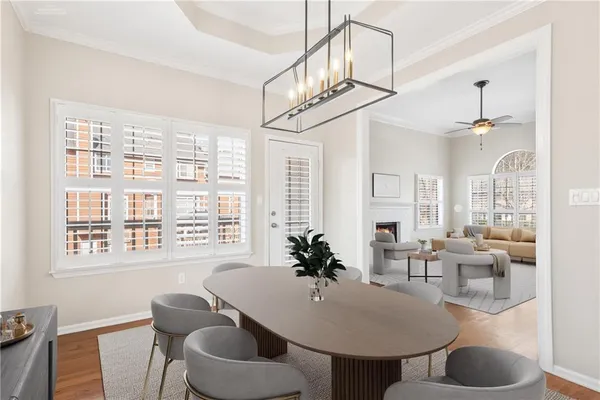 a dining room with furniture a chandelier and wooden floor