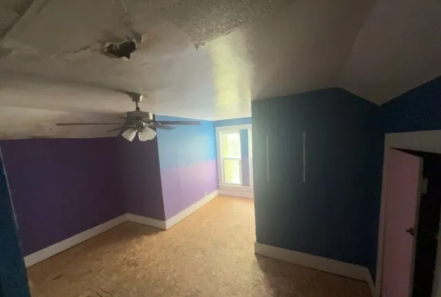 an empty room with a empty space and chandelier fan