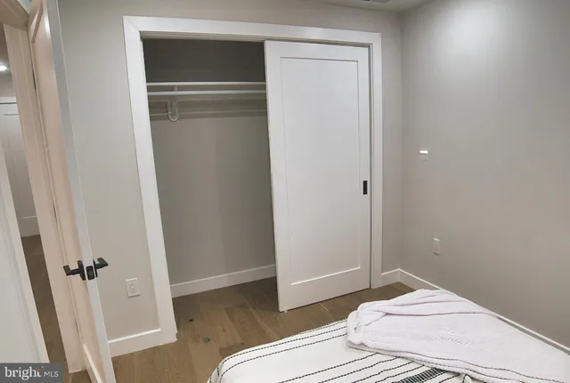 a bedroom with a bed and hardwood floor