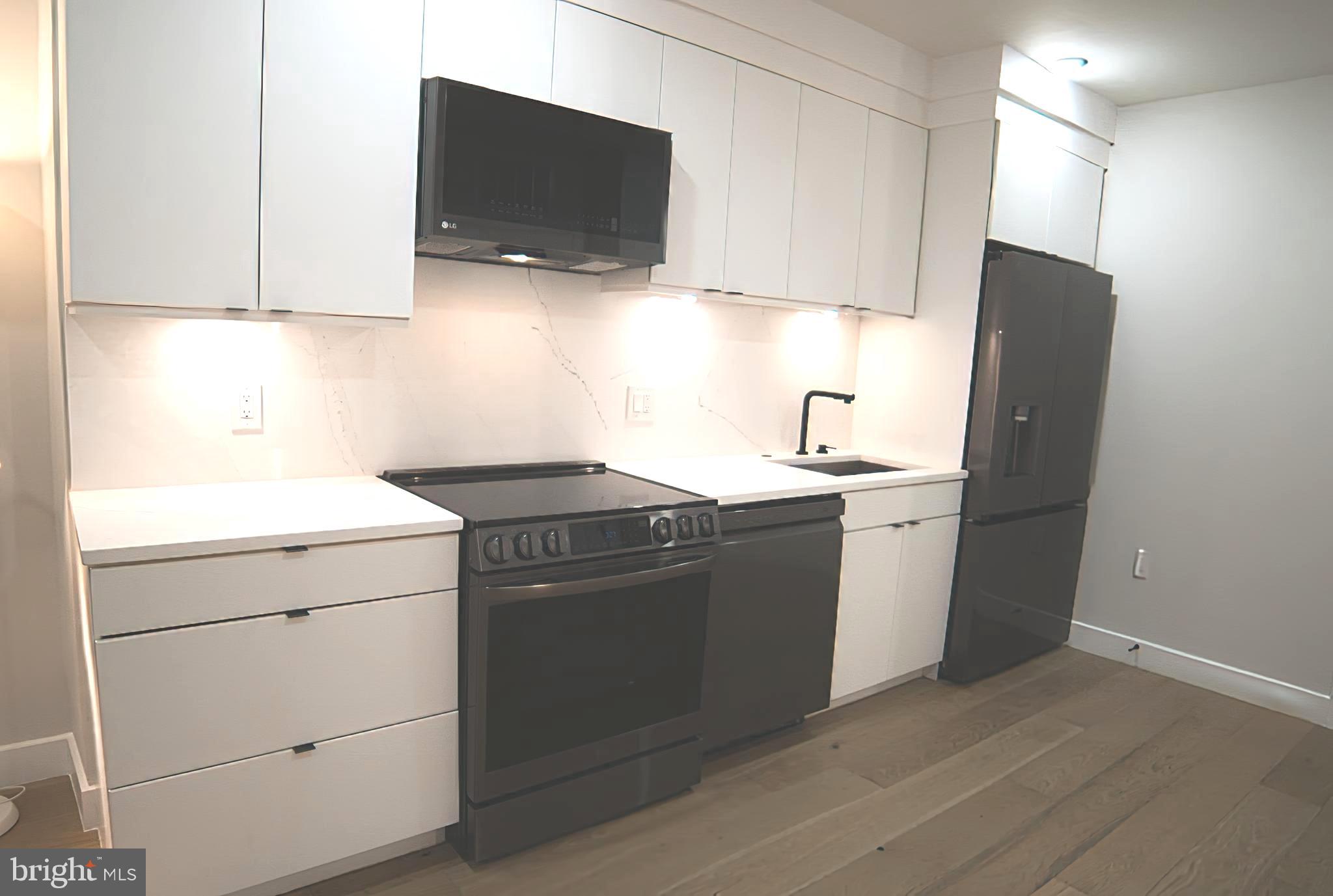 1208 M Street Northwest, Unit 2 Washington, DC 20005 - Photo 6 of 25 a kitchen with a sink and a stove top oven with wooden floor