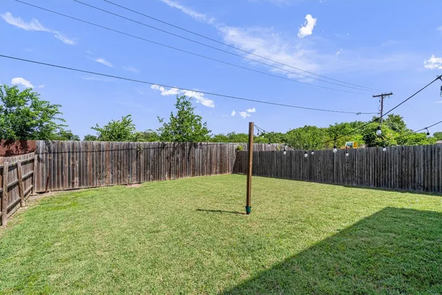 a view of a house with brick walls and a yard with plants